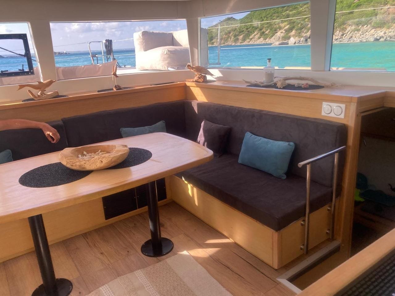 The catamaran's indoor saloon, dining table and benches