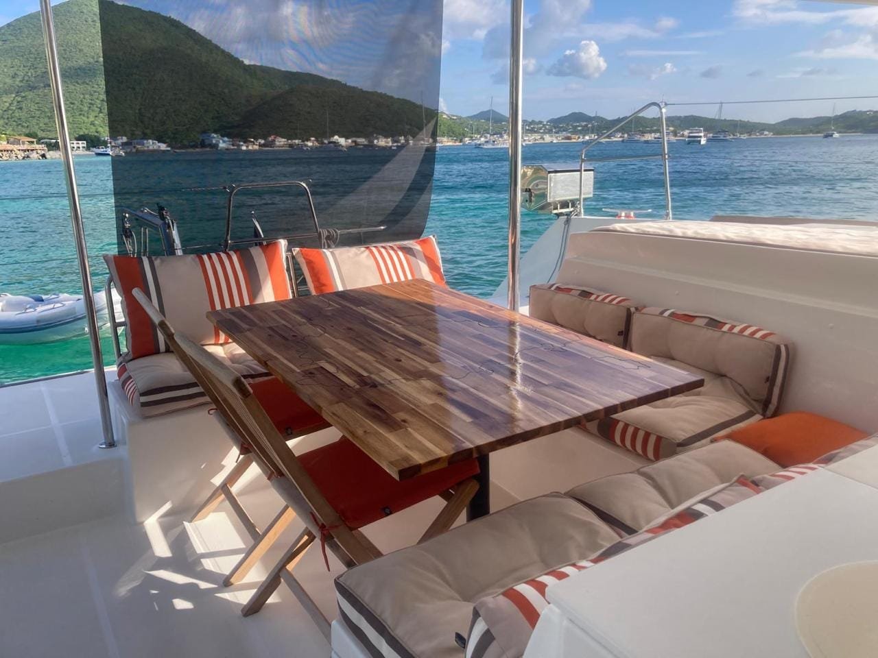 The shaded cockpit of the catamaran, table and benches under the bimini